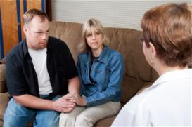 Therapist talking with couple on couch