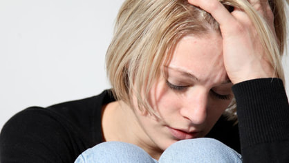Contemplative woman with hand on forehead