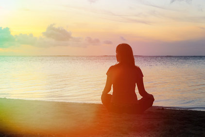 Silhouette of woman sitting on beach